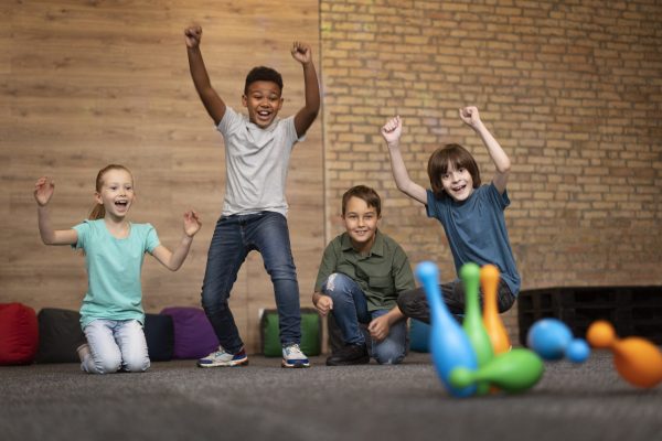 Full Shot Smiley Kids Playing Bowling - Harmony ABA Centers